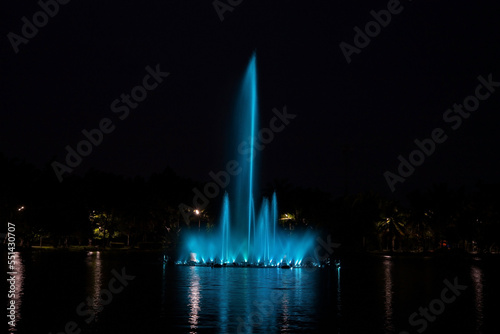 Blue fountain at night in the pond