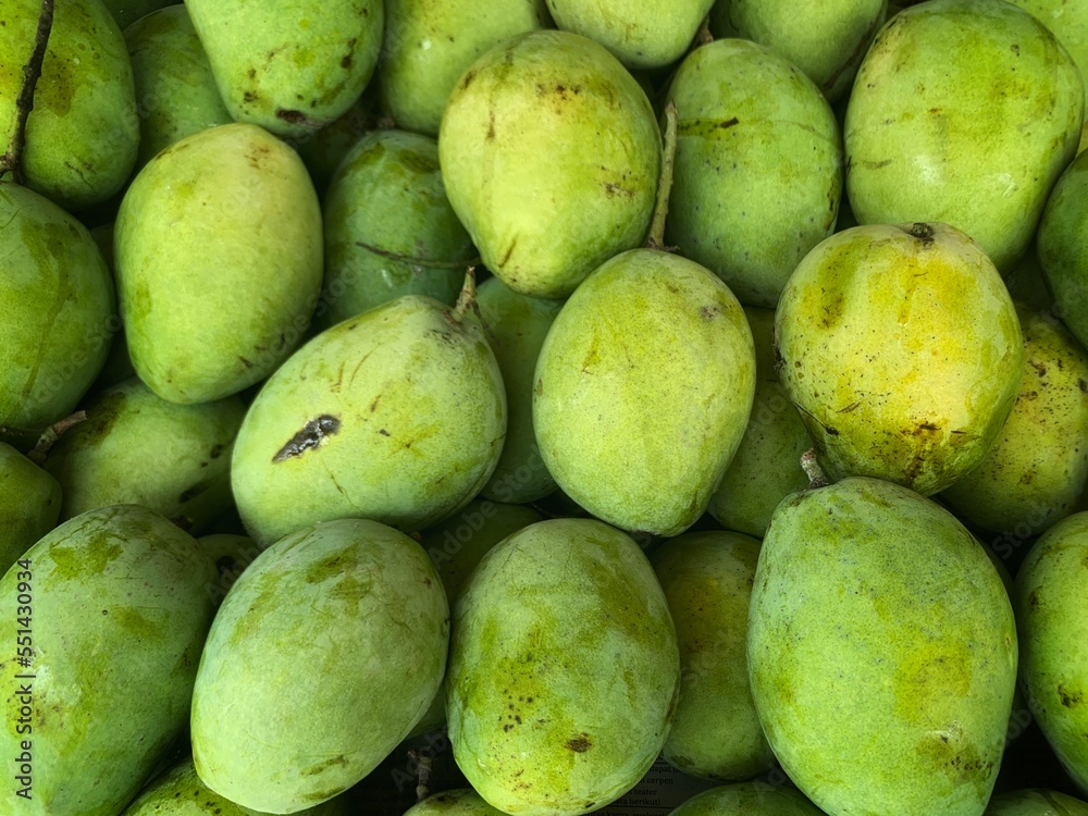 pile of fresh mangoes for sale in the market. healthy fruit full of vitamins pile of fresh mangoes for sale in the market. healthy fruit full of vitamins