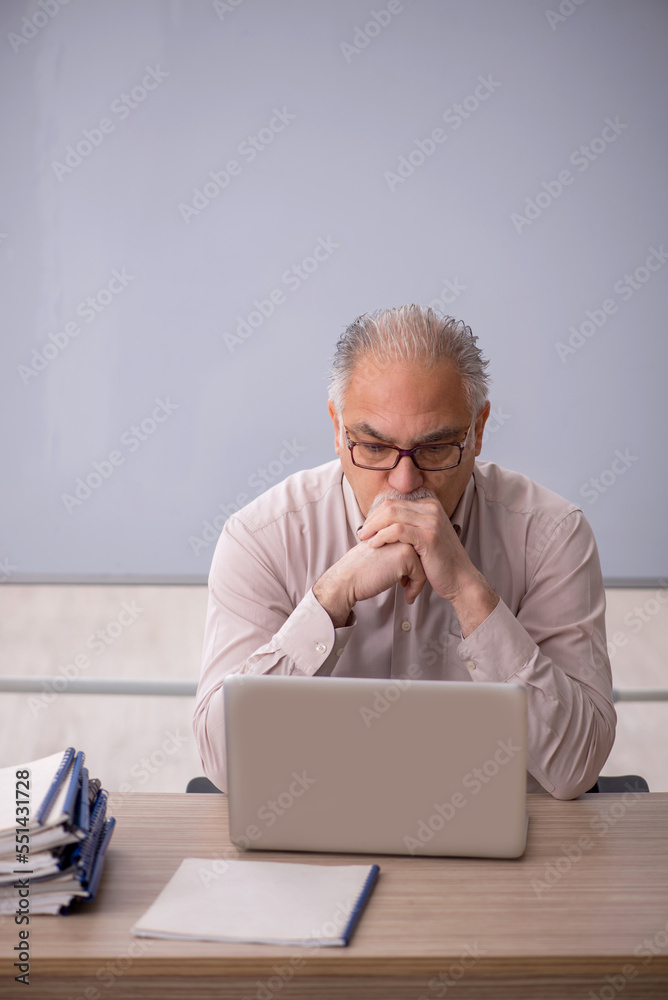 Old male teacher in front of whiteboard Old male teacher in front of whiteboard