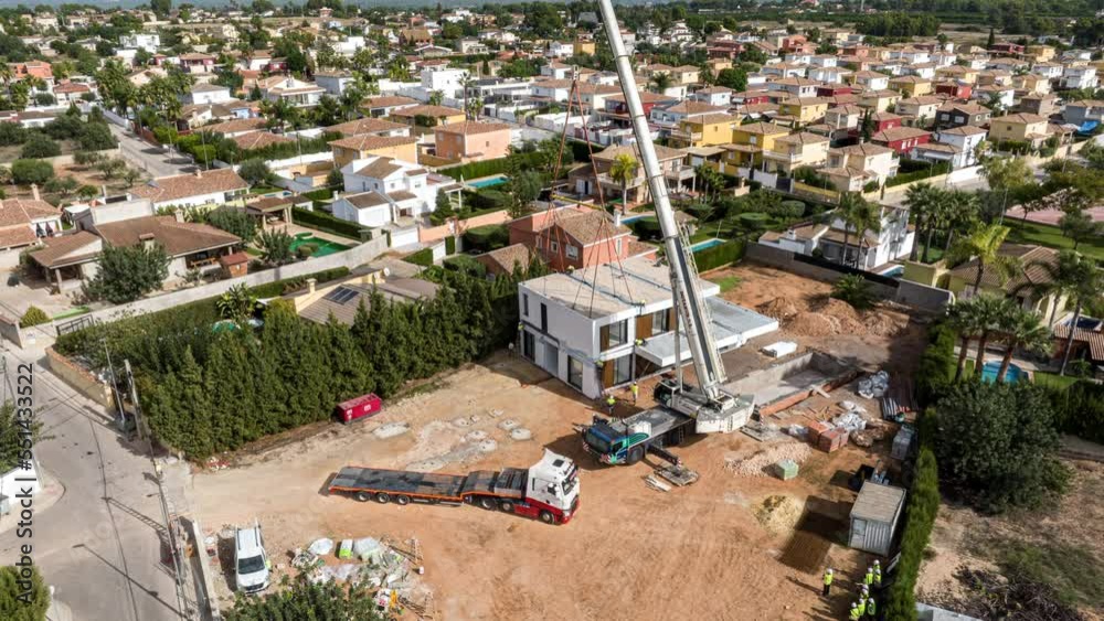 Hyperlapse of crane stacking modules for construction of prefabricated building. Aerial backward ascending