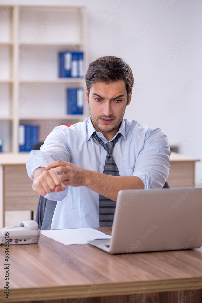 Young male employee unhappy with excessive work in the office