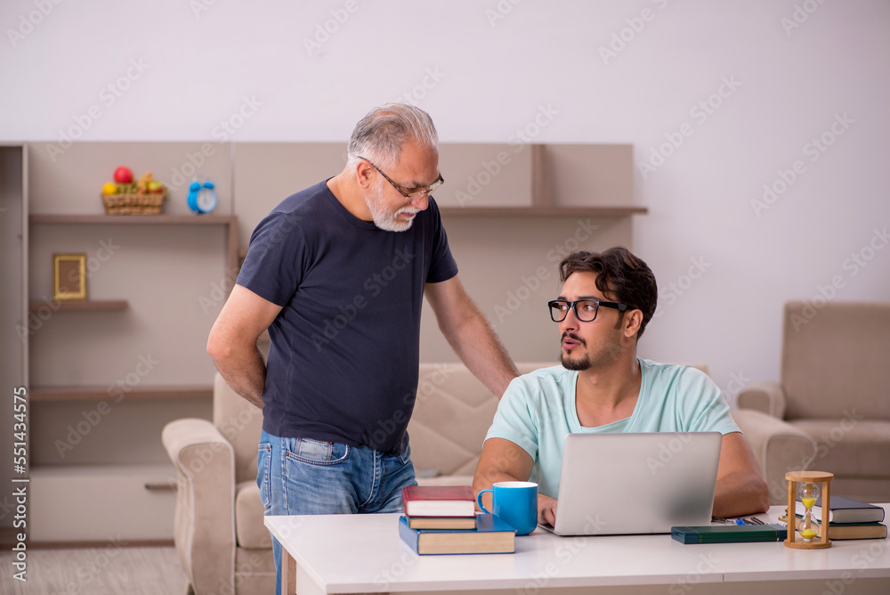 Young male student and his grandfather at home Young male student and his grandfather at home