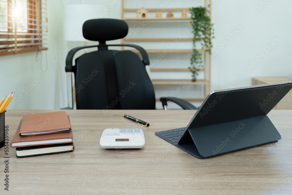 Fototapeta premium Tablet computer, notebook, calculator and coffee cup on the desk in the office