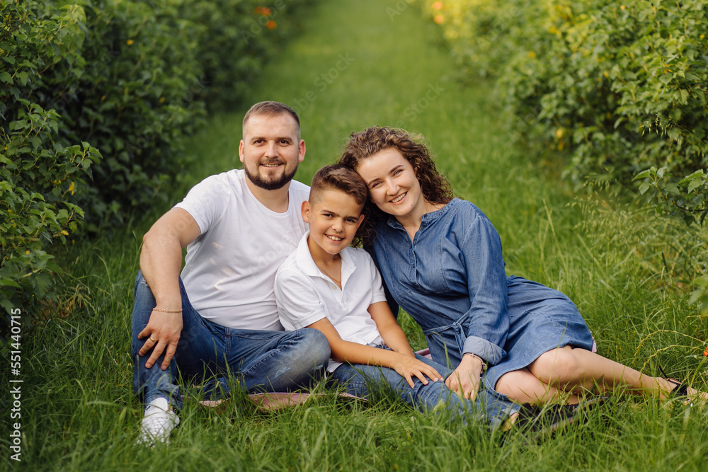 Young family looking at the camera while walking in the garden Young family looking at the camera while walking in the garden