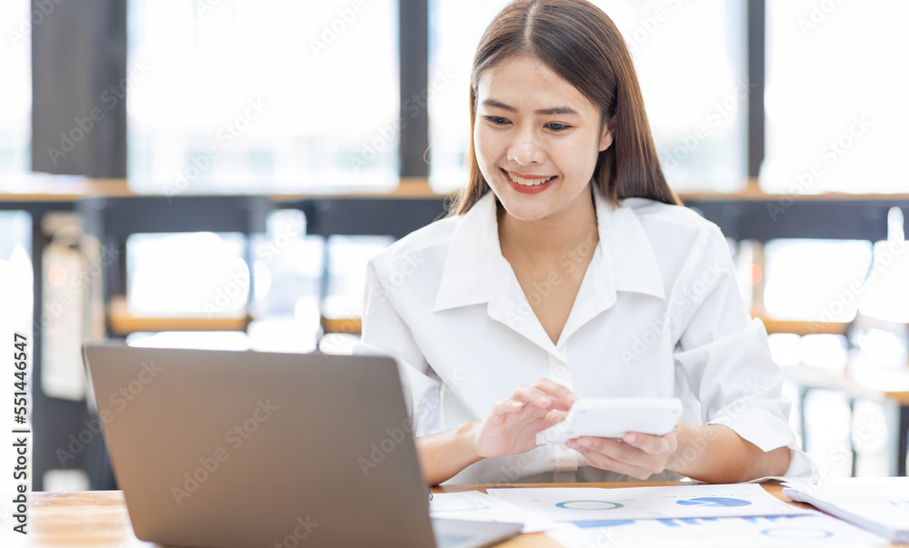 Asian Businesswoman Using laptop computer and working at office with calculator document on desk, doing planning analyzing the financial report, business plan investment, finance analysis concept.
Asian Businesswoman Using laptop computer and working at office with calculator document on desk, doing planning analyzing the financial report, business plan investment, finance analysis concept.