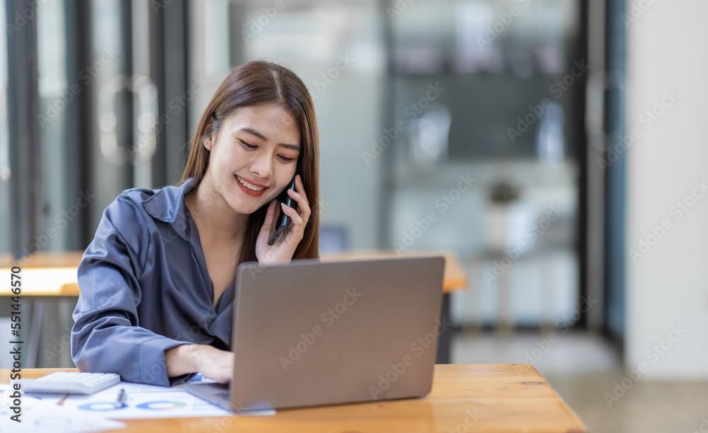 Asian Businesswoman Using laptop computer and working at office with calculator document on desk, doing planning analyzing the financial report, business plan investment, finance analysis concept.
Asian Businesswoman Using laptop computer and working at office with calculator document on desk, doing planning analyzing the financial report, business plan investment, finance analysis concept.