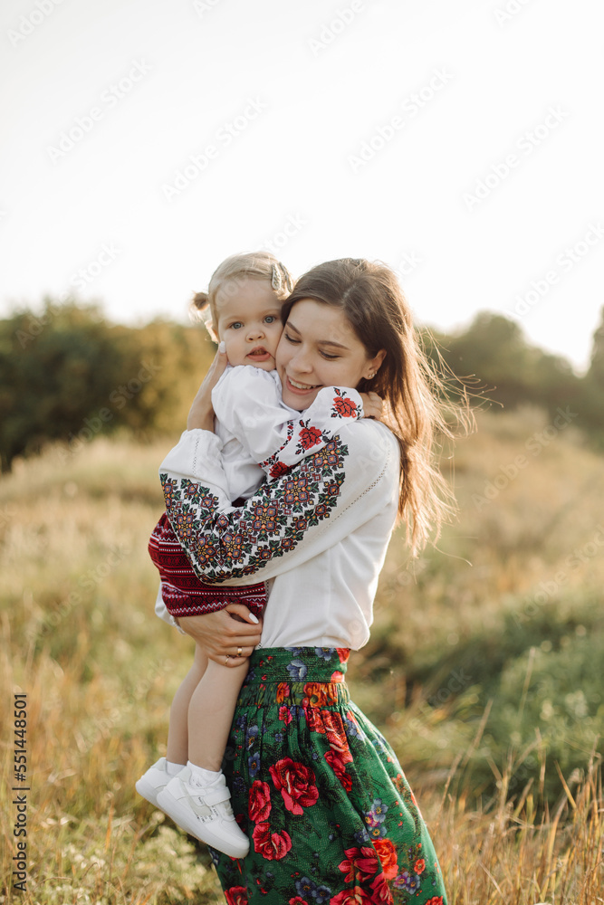 Beautiful family with kid in traditional ethnic dress in a countryside, park Beautiful family with kid in traditional ethnic dress in a countryside, park