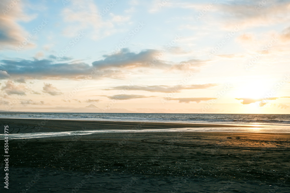 Beach in silhouette as sunsets on distant horizon over ocean. Beach in silhouette as sunsets on distant horizon over ocean.