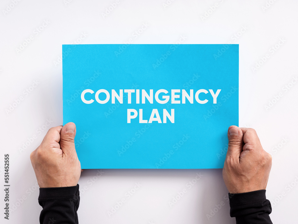 Male hand holding a blue paper with the message contingency plan. Male hand holding a blue paper with the message contingency plan.
