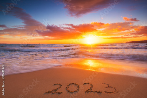 Happy New Year 2023 travel and lifestyle concept, text lettering on the beach shore. Ocean sunrise. Sea sunset.