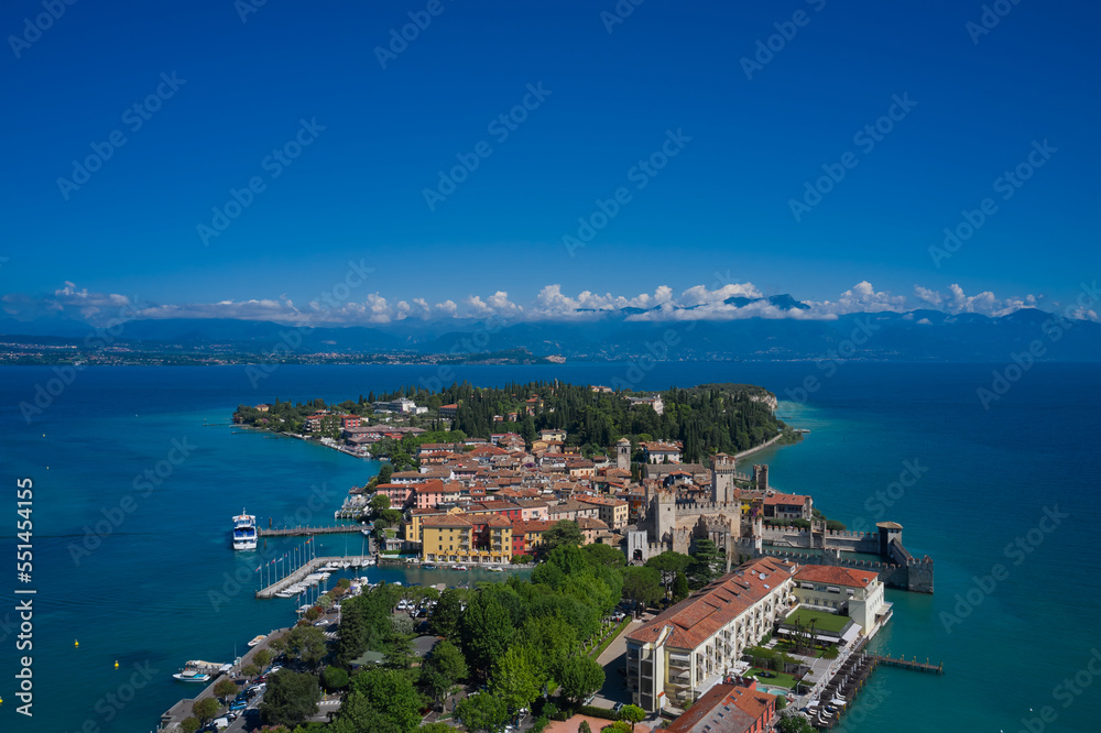 View of the Italian town of Sirmione and Lake Garda. Aerial view on Sirmione sul Garda. Italy, Lombardy.  Rocca Scaligera Castle in Sirmione. Aerial photography with drone.