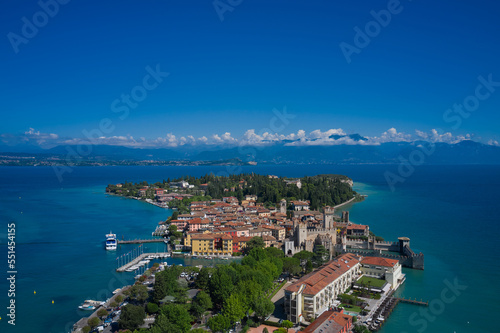 View of the Italian town of Sirmione and Lake Garda. Aerial view on Sirmione sul Garda. Italy, Lombardy. Rocca Scaligera Castle in Sirmione. Aerial photography with drone.