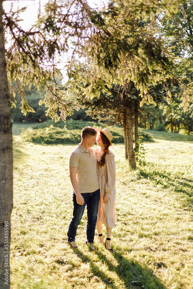 Fototapeta premium Young couple in love outdoor.Stunning sensual outdoor portrait of young stylish fashion couple posing in summer in field