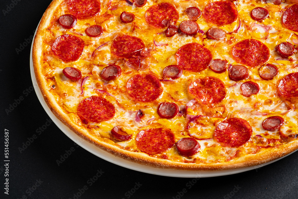 salami pizza on the black background salami pizza on the black background