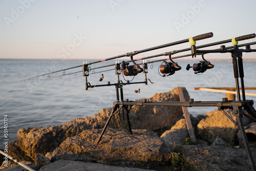 Spinning rods on a professional fishing rod stand outdoors