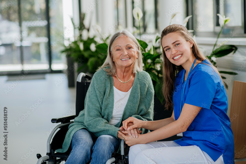Young woman doctor taking care of senior woman at wheelchair. Young woman doctor taking care of senior woman at wheelchair.