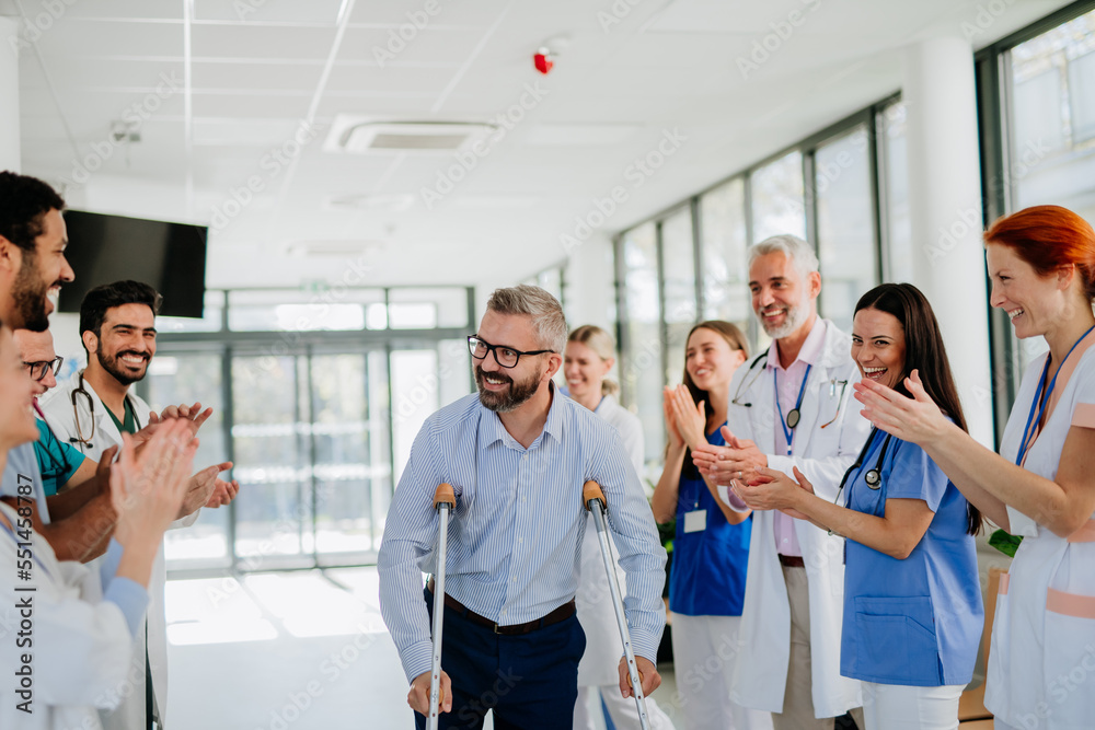 Medical staff clapping to patient who recovered from serious accident. Medical staff clapping to patient who recovered from serious accident.