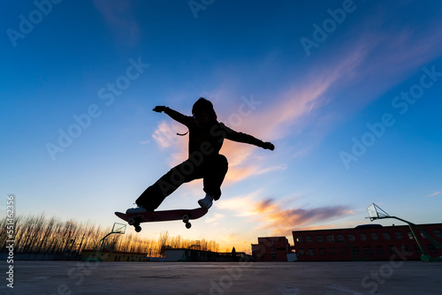 In the evening, a boy is playing skateboard. © zhengzaishanchu