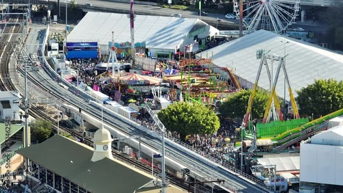 Aerial shot of Brisbane Showgrounds during the Ekka carnival celebration, with track station in centre view, with very busy crowd attending the rides and attractions, Brisbane QLD photo