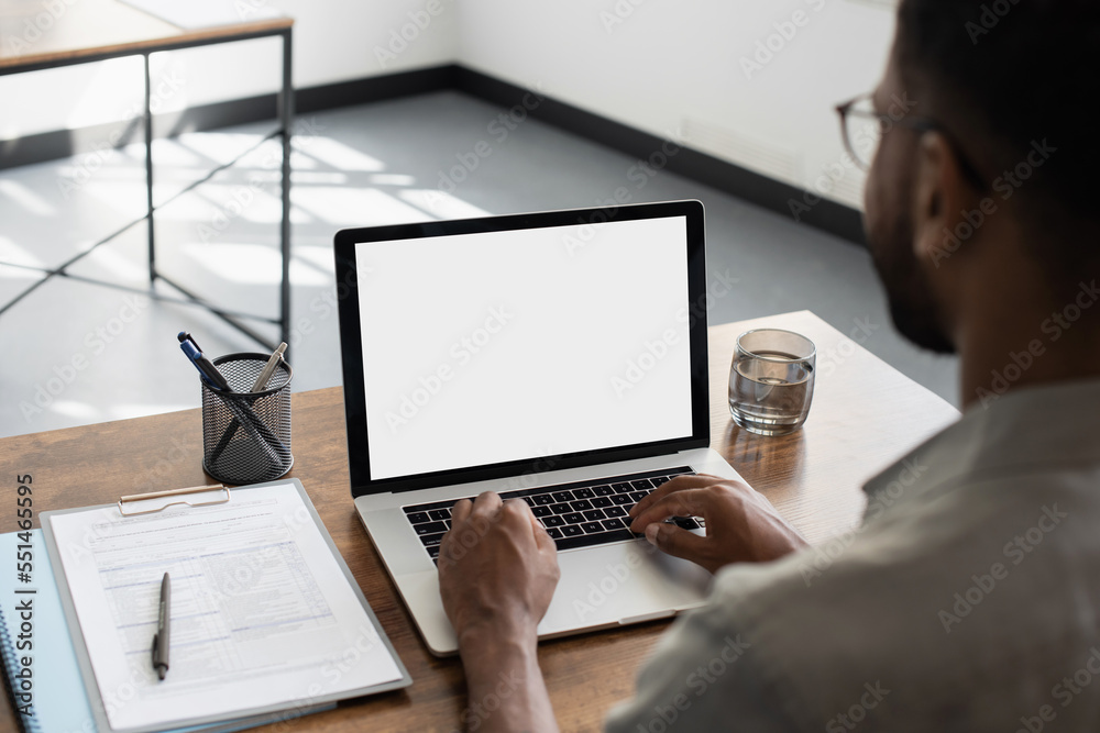 Young man using laptop computer with blank empty mockup screen. Business man working at office. Freelance, student lifestyle, e-learning, shopping online, web site, technology concept - obrazy, fototapety, plakaty 