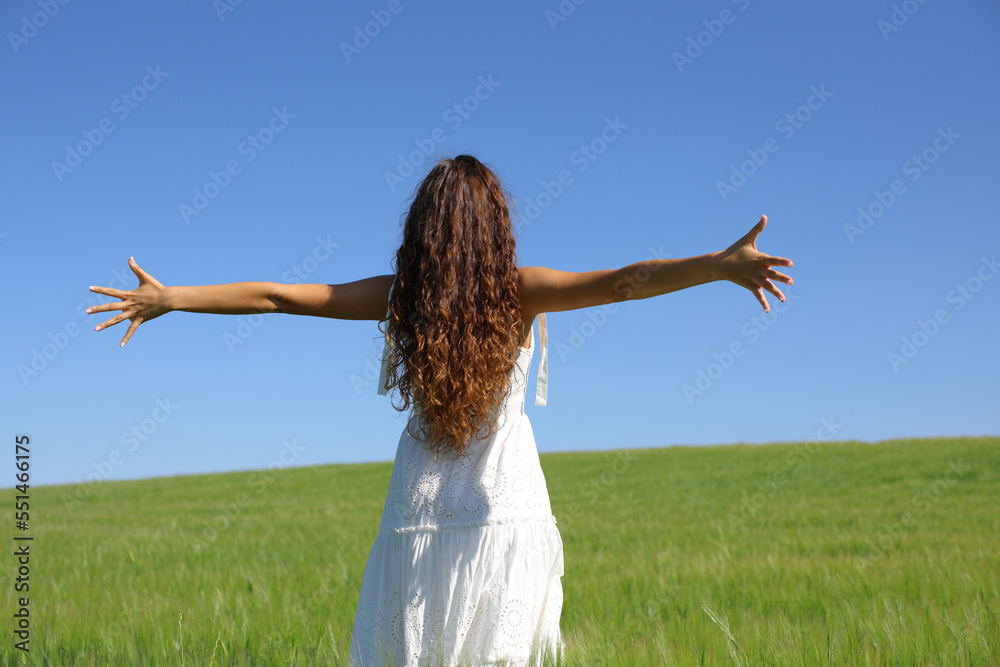 Woman with white dress celebrating outstretching arms Woman with white dress celebrating outstretching arms