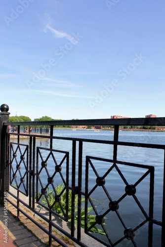Fence on the shore of the lake in the city park