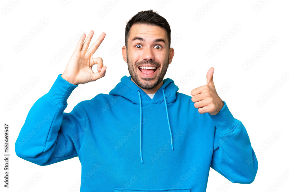 Young handsome caucasian man over isolated chroma key background showing ok sign and thumb up gesture