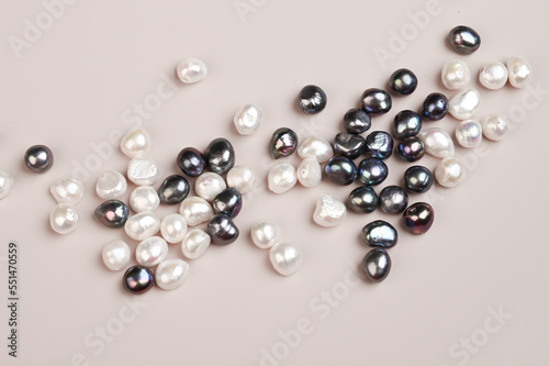 Black and white pearl on pastel background top view. Natural freshwater pearls