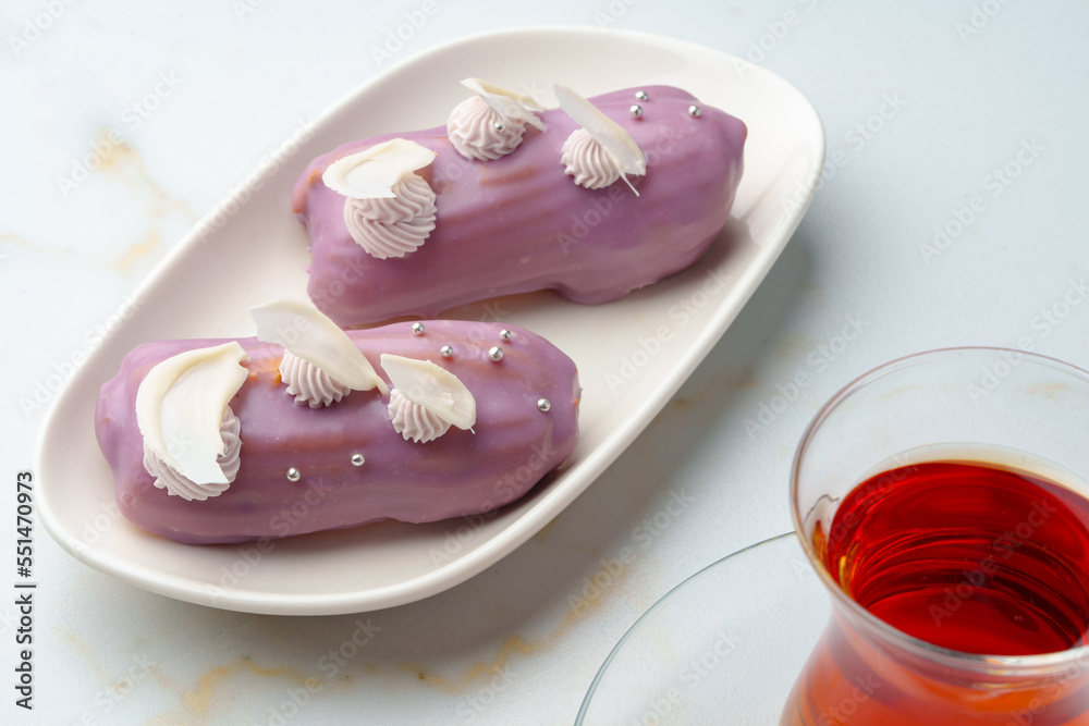 Two eclair cakes with violet frosting on white plate Two eclair cakes with violet frosting on white plate