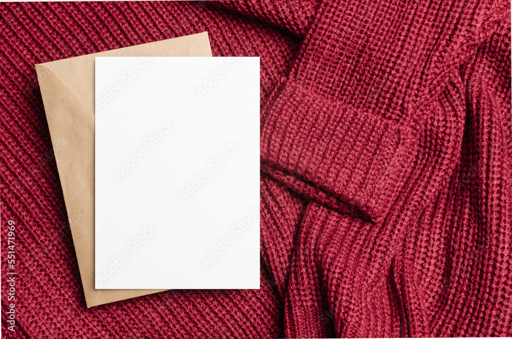 Blank greeting card mockup on red knitted background Blank greeting card mockup on red knitted background
