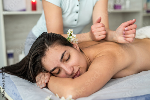 young woman having back massage at spa