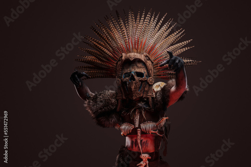 Shot of creepy zombie woman dressed in dark aboriginal attire and ceremonial headdress.