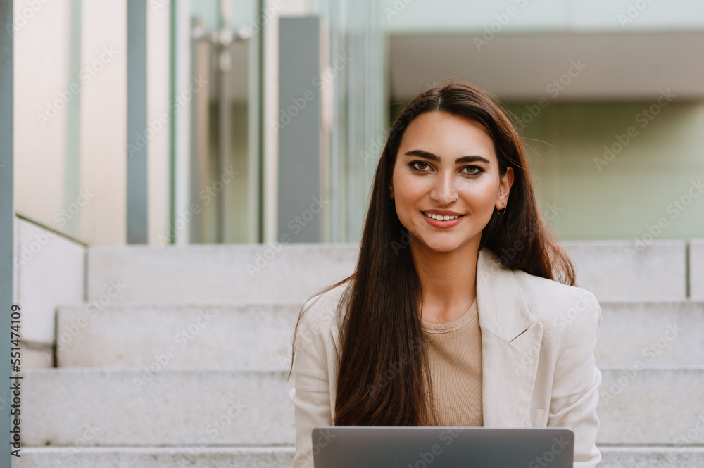 Young indian student woman working with laptop while sitting on stairs Young indian student woman working with laptop while sitting on stairs