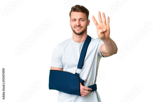 Young caucasian man with broken arm and wearing a sling over isolated chroma key background happy and counting four with fingers