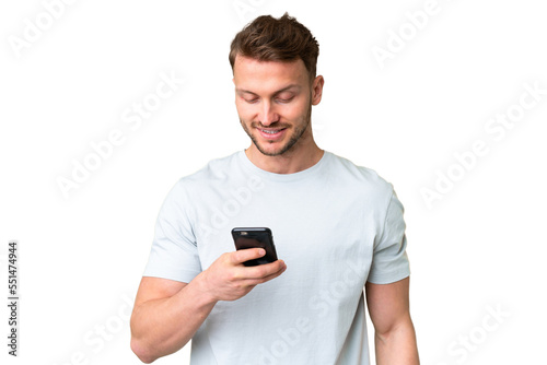 Young handsome caucasian man over isolated chroma key background sending a message or email with the mobile © luismolinero