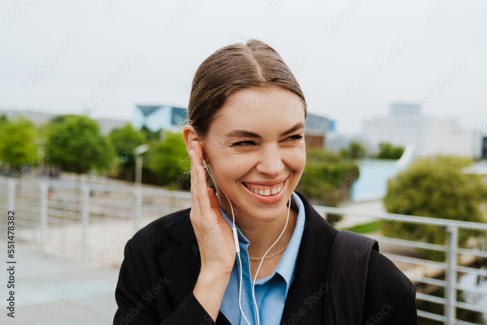 Young woman in earphones standing at the street Young woman in earphones standing at the street