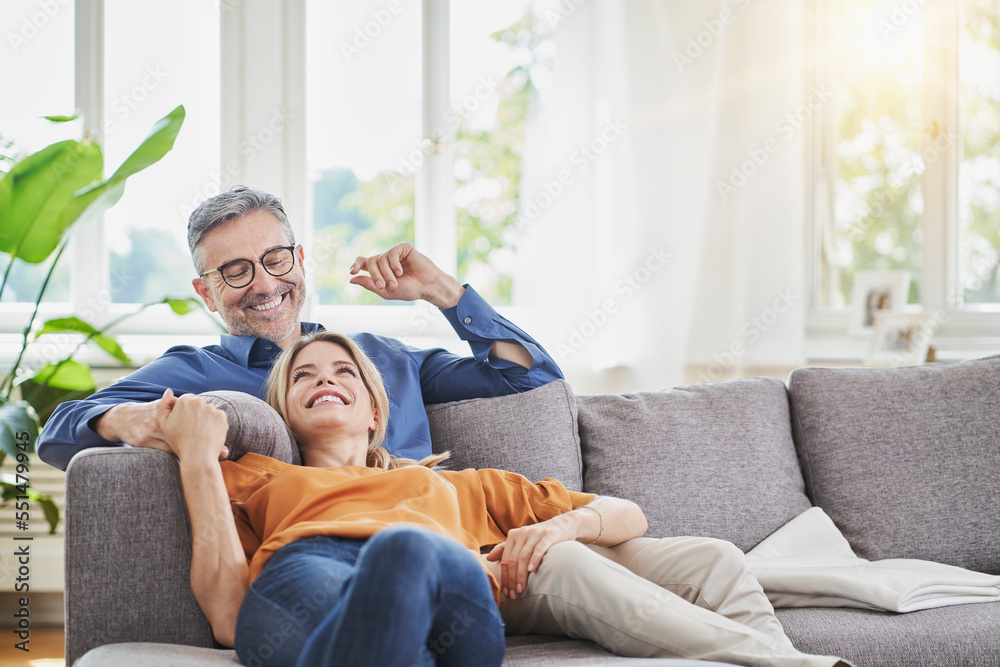 Smiling couple on sofa in living room Smiling couple on sofa in living room