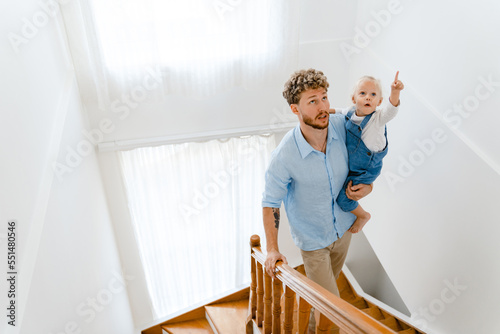 Young white father going down on stairs with little daughter at home © Drobot Dean