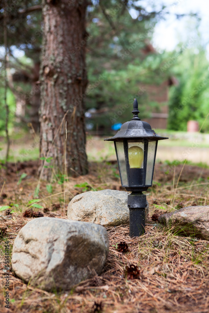 Pole with electric lamp as landscape design, lighting of the pathway in forest