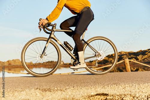 Young cyclist riding bicycle on road photo