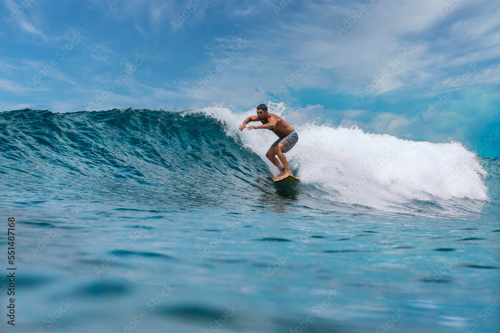 Shirtless male surfer on a wave at sunny day