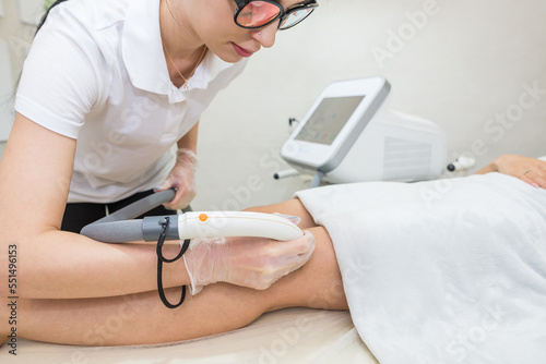 Hair removal on the legs, laser procedure at medical clinic.