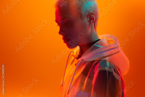 Androgynous woman under bright neon light