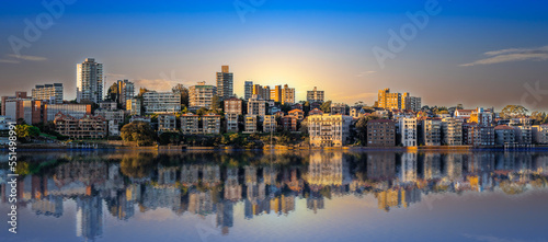 Panorama of Sydney Harbour Australia at Sunset with the reflection of the Buildings and high rise offices of the City in the water