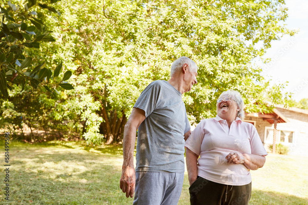 Retired couple happily laughing at a joke in the park Retired couple happily laughing at a joke in the park