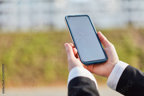 Hands of businesswoman holding smartphone as mock-up template photo