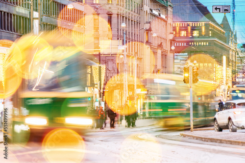 Effect Bokeh Abstract Background Photo With Tram Departs In Motion Blur From Stop On Mannerheim Avenue In Helsinki. Night View Of Mannerheim Avenue In Evening Illumination Boke Blured View. photo