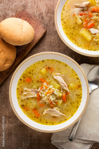 Top view of homemade rice and chicken soup in a bowl. Topmview, vertical image. photo