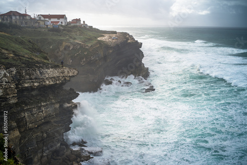picturesque fishing village of Azenhas do Mar on the coast of Portugal. Traditional white houses built on a cliff above the ocean. Cloudy, rainy day, rough ocean. Horizontally photo