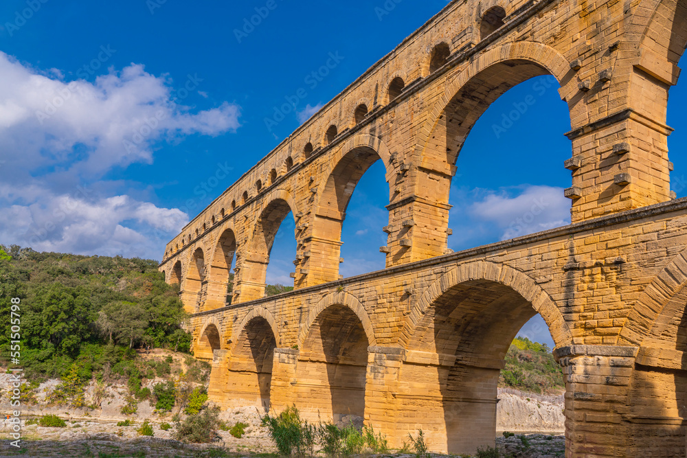 Pont du Gard three-tiered aqueduct from orange shelly limestone at the river Gardon.